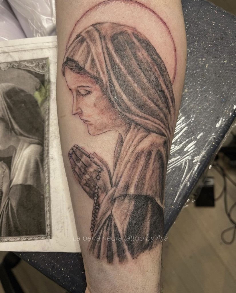 聖母マリアみたいな人が目を瞑って拝んでいる絵のタトゥー